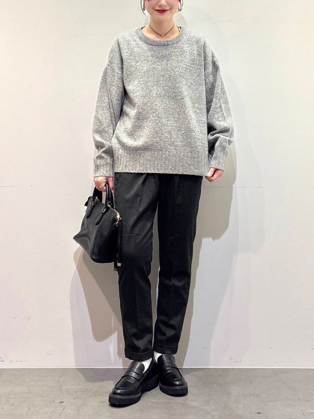 グレー系のニット/セーター、ブラック系のボストンバッグ、グレー系のその他パンツを着用したレディースの冬コーディネートの4枚目の写真