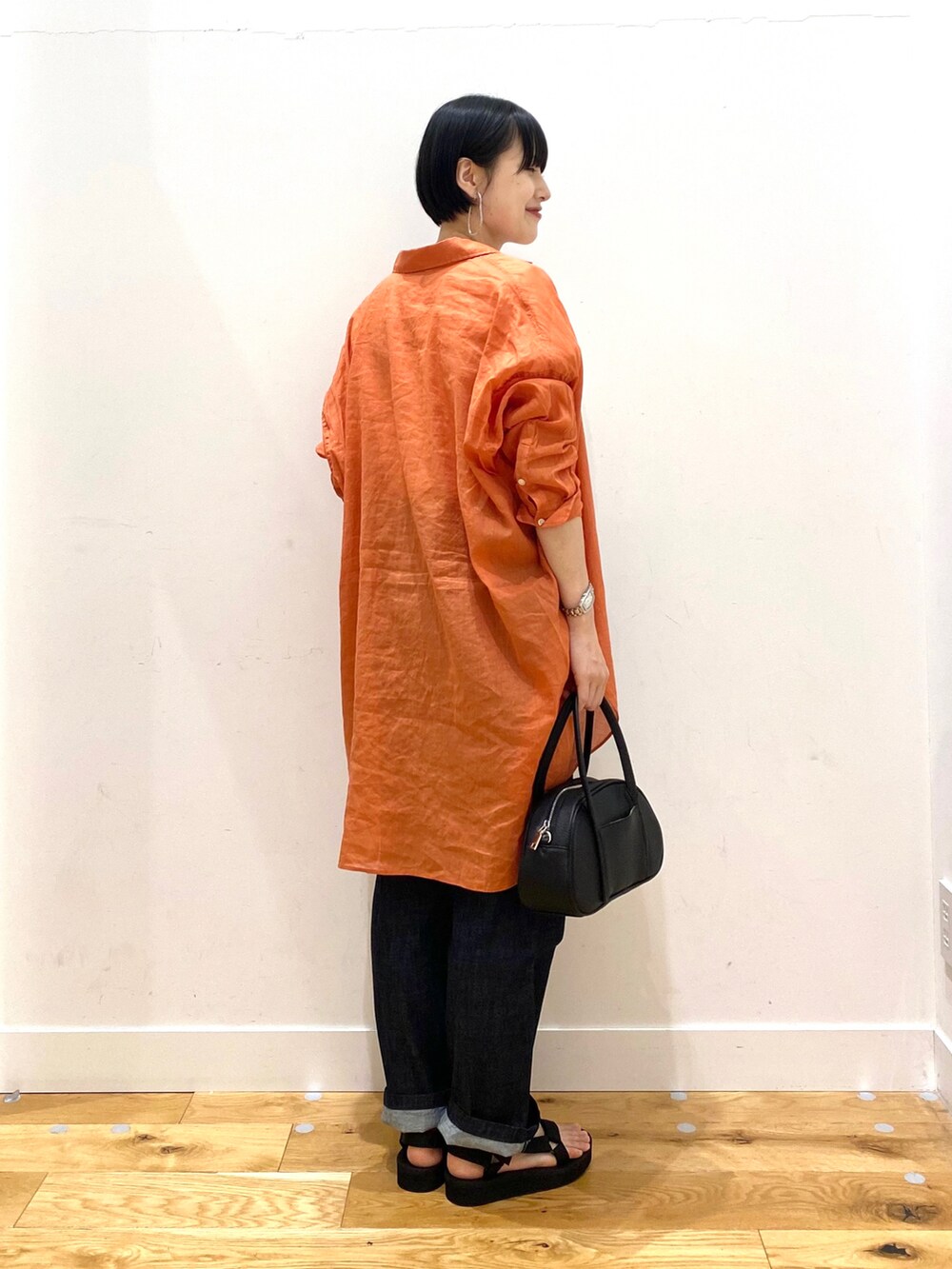 オレンジ系のシャツ/ブラウス、ホワイト系のTシャツ/カットソー、ブルー系のデニムパンツを着用したレディースの春コーディネートの3枚目の写真