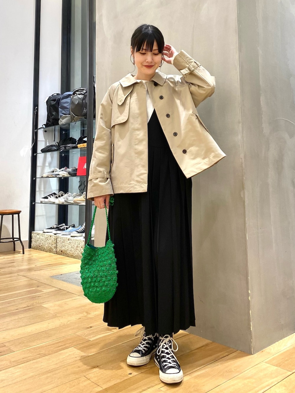 ベージュ系のトレンチコート、ホワイト系のTシャツ/カットソー、ブラック系のワンピースを着用したレディースの冬コーディネートの2枚目の写真