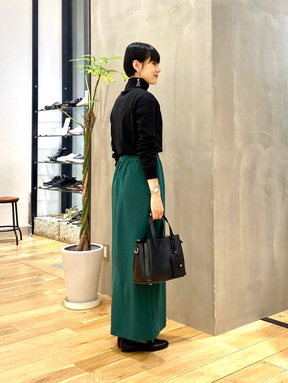 ホワイト系のノーカラージャケット、ブラック系のTシャツ/カットソー、グリーン系のスカートを着用したレディースの秋コーディネートの4枚目の写真