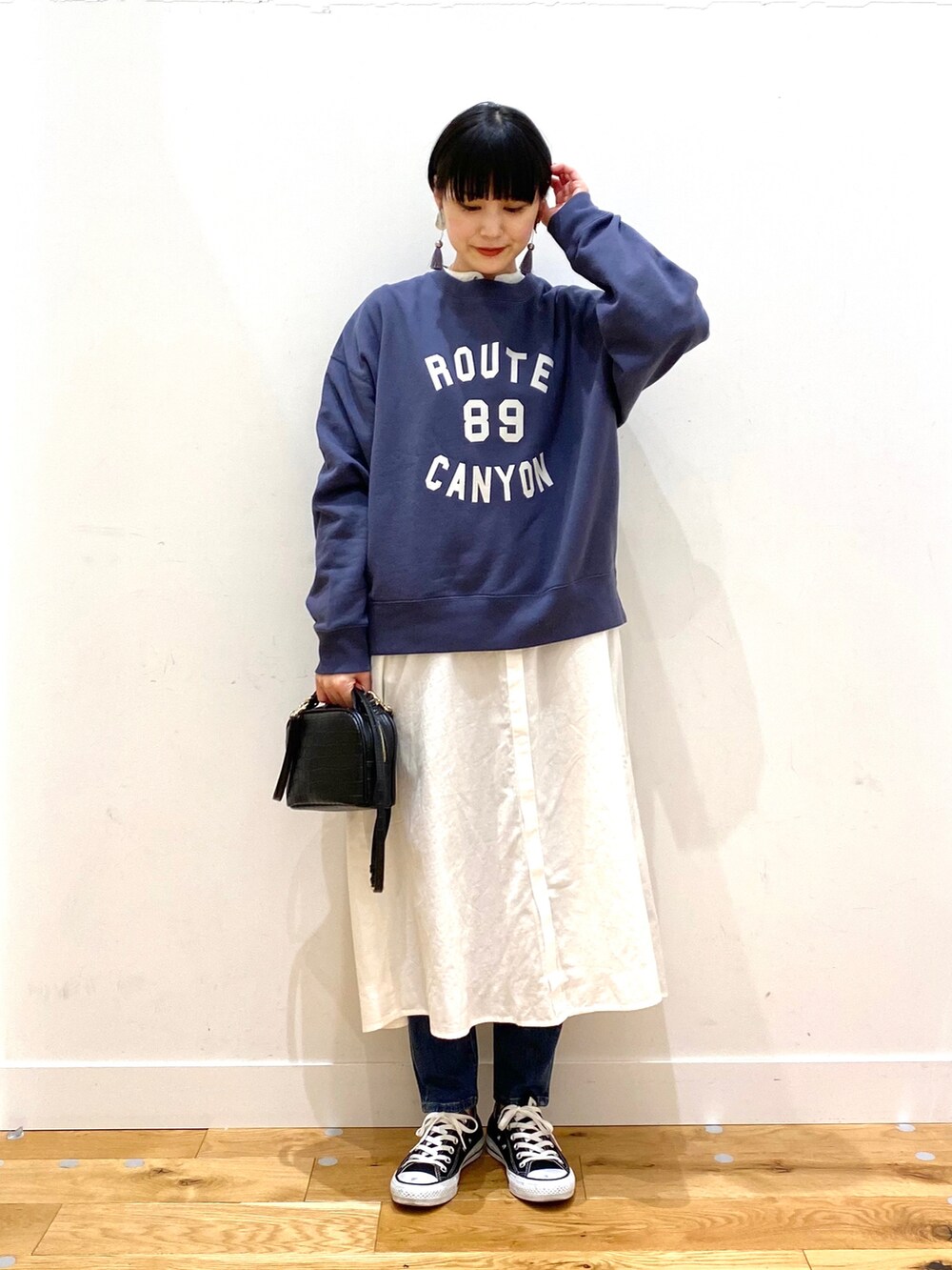 ブラック系のダウンジャケット/コート、ブルー系のスウェット、ホワイト系のワンピースを着用したレディースの冬コーディネートの3枚目の写真