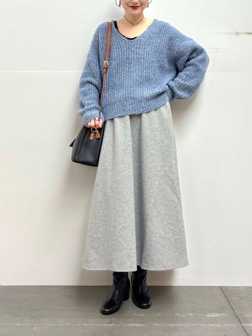 ブラック系のブーツ、ブラック系のトートバッグ、グレー系のスカートを着用したレディースの冬コーディネートの4枚目の写真