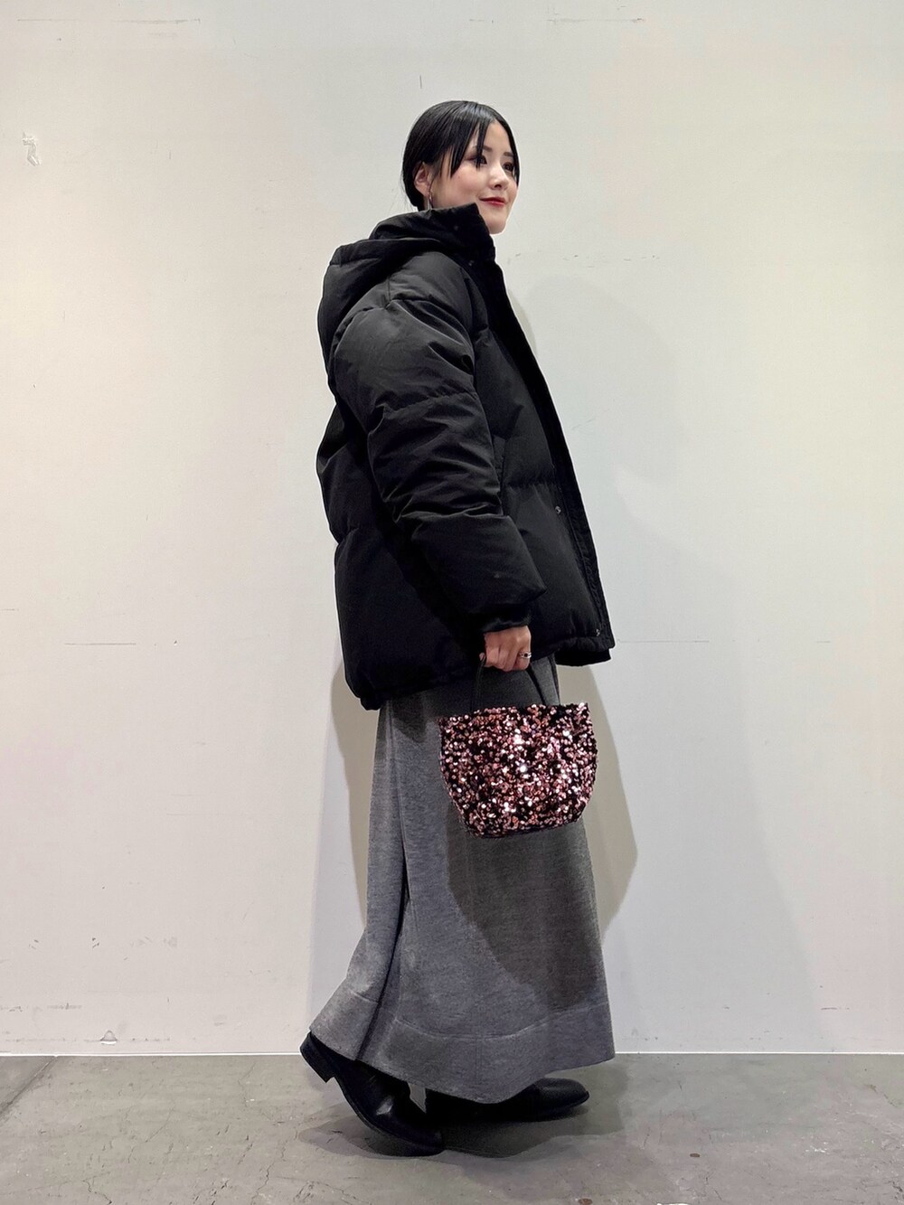 ブラック系のダウンジャケット/コート、グレー系のワンピース、ピンク系のショルダーバッグを着用したレディースの冬コーディネートの2枚目の写真