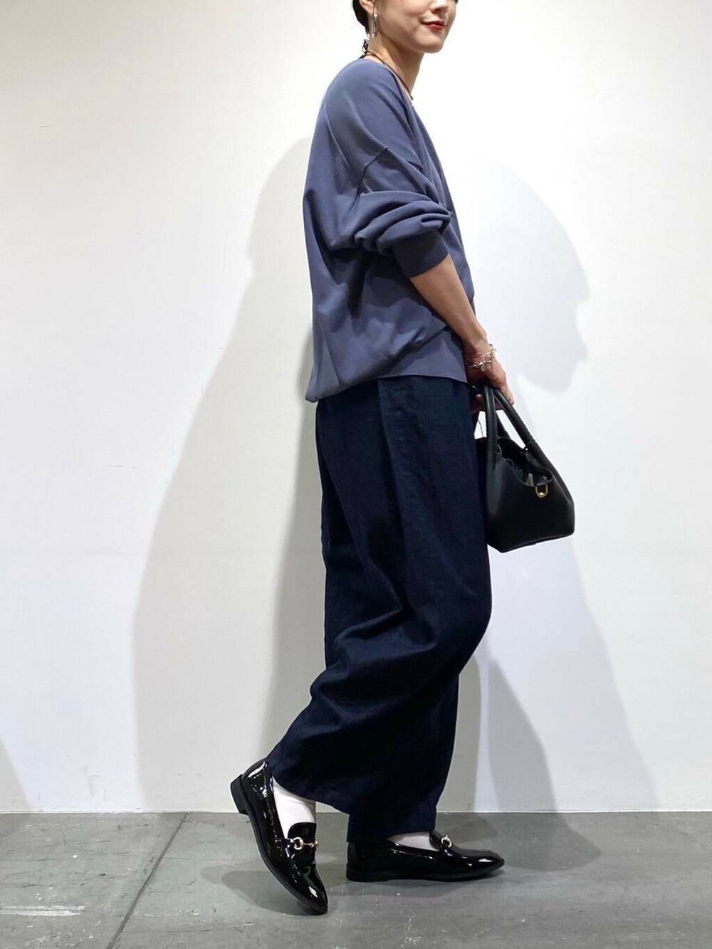 ブラック系のローファー、ブルー系のデニムパンツ、ブルー系のカーディガン/ボレロを着用したレディースの秋コーディネートの6枚目の写真