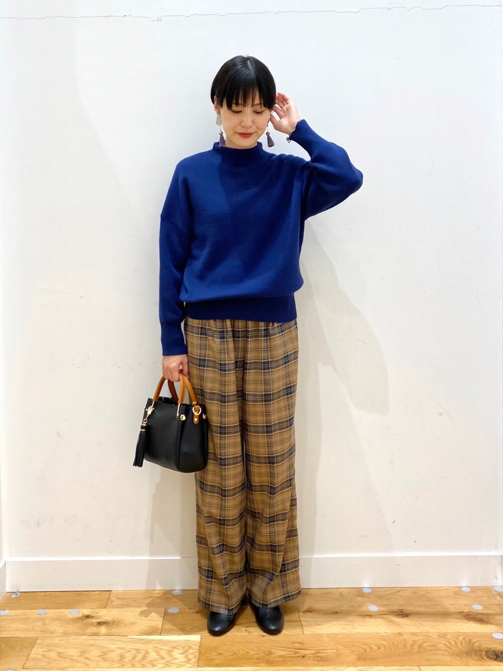 グレー系のチェスターコート、ブルー系のニット/セーター、ベージュ系のその他パンツを着用したレディースの秋コーディネートの3枚目の写真