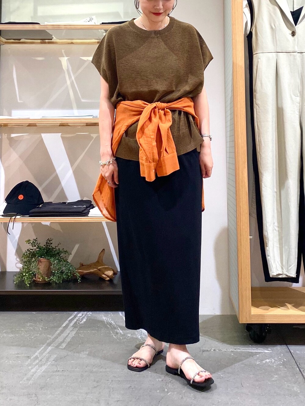 ブラウン系のニット/セーター、オレンジ系のシャツ/ブラウス、ブラック系のスカートを着用したレディースの夏コーディネートの6枚目の写真