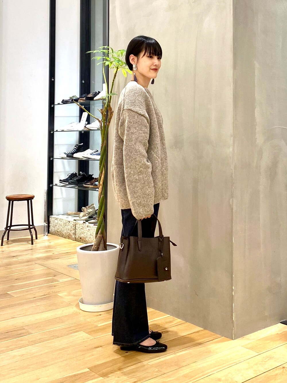 グレー系のカーディガン/ボレロ、ホワイト系のTシャツ/カットソー、ブルー系のデニムパンツを着用したレディースの秋コーディネートの3枚目の写真