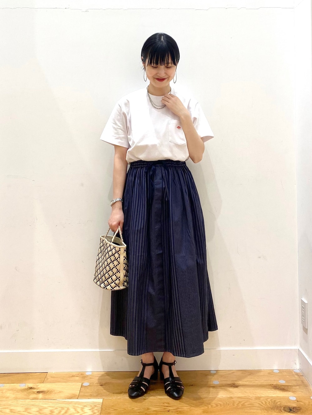 グレー系のスカート、ブラック系のサンダル、ホワイト系のその他を着用したレディースの春コーディネートの2枚目の写真