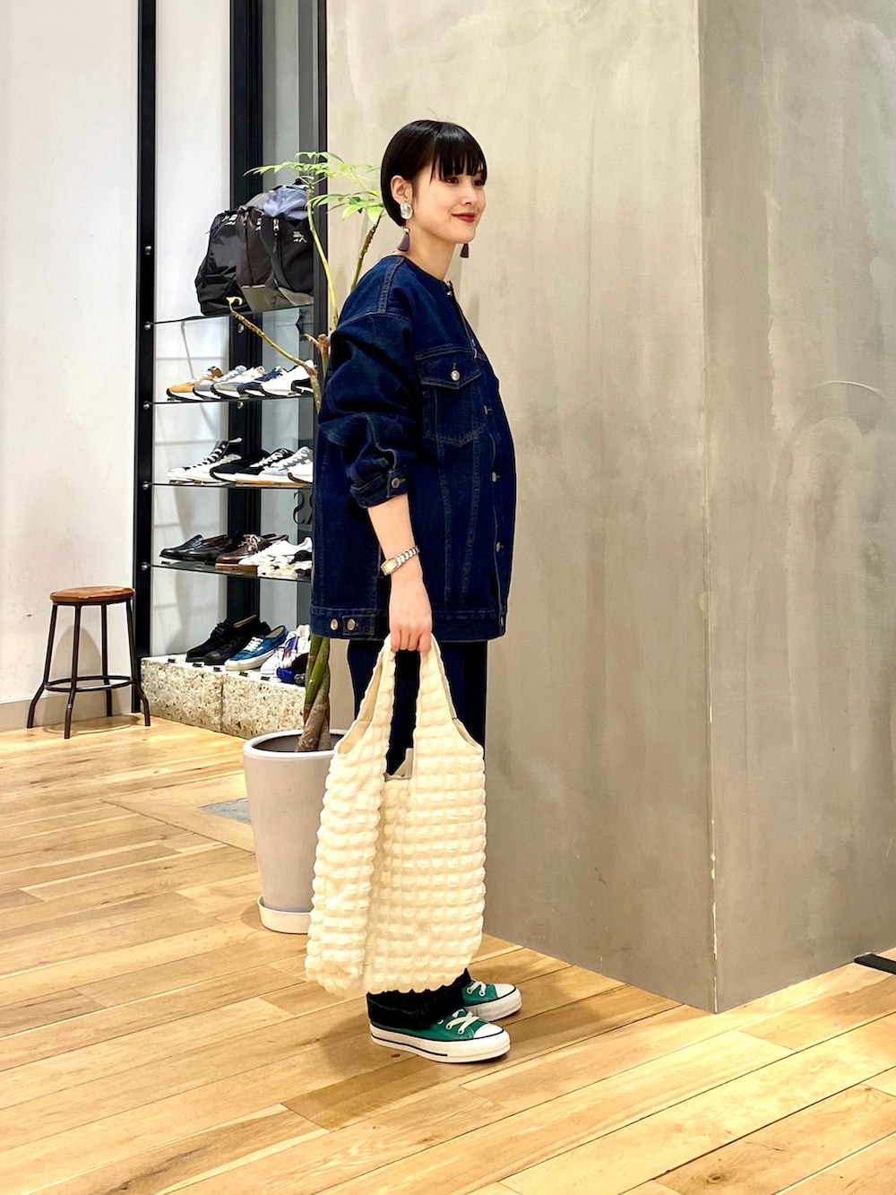 ブルー系のデニムジャケット、ブルー系のデニムパンツ、ホワイト系のトートバッグを着用したレディースの冬コーディネートの3枚目の写真