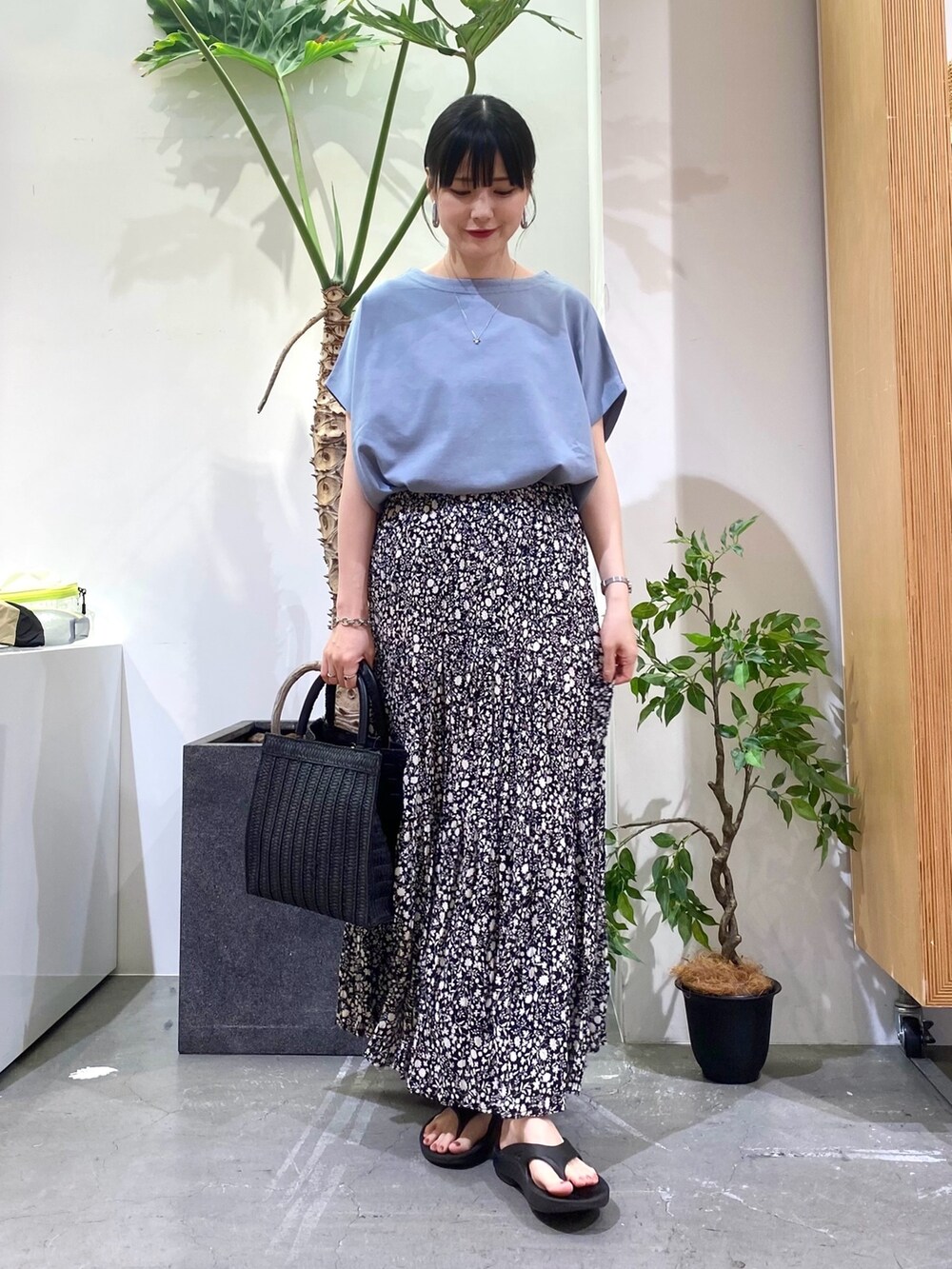 ブルー系のTシャツ/カットソー、ブラック系のスカート、ブラック系のハンドバッグを着用したレディースの春コーディネートの2枚目の写真