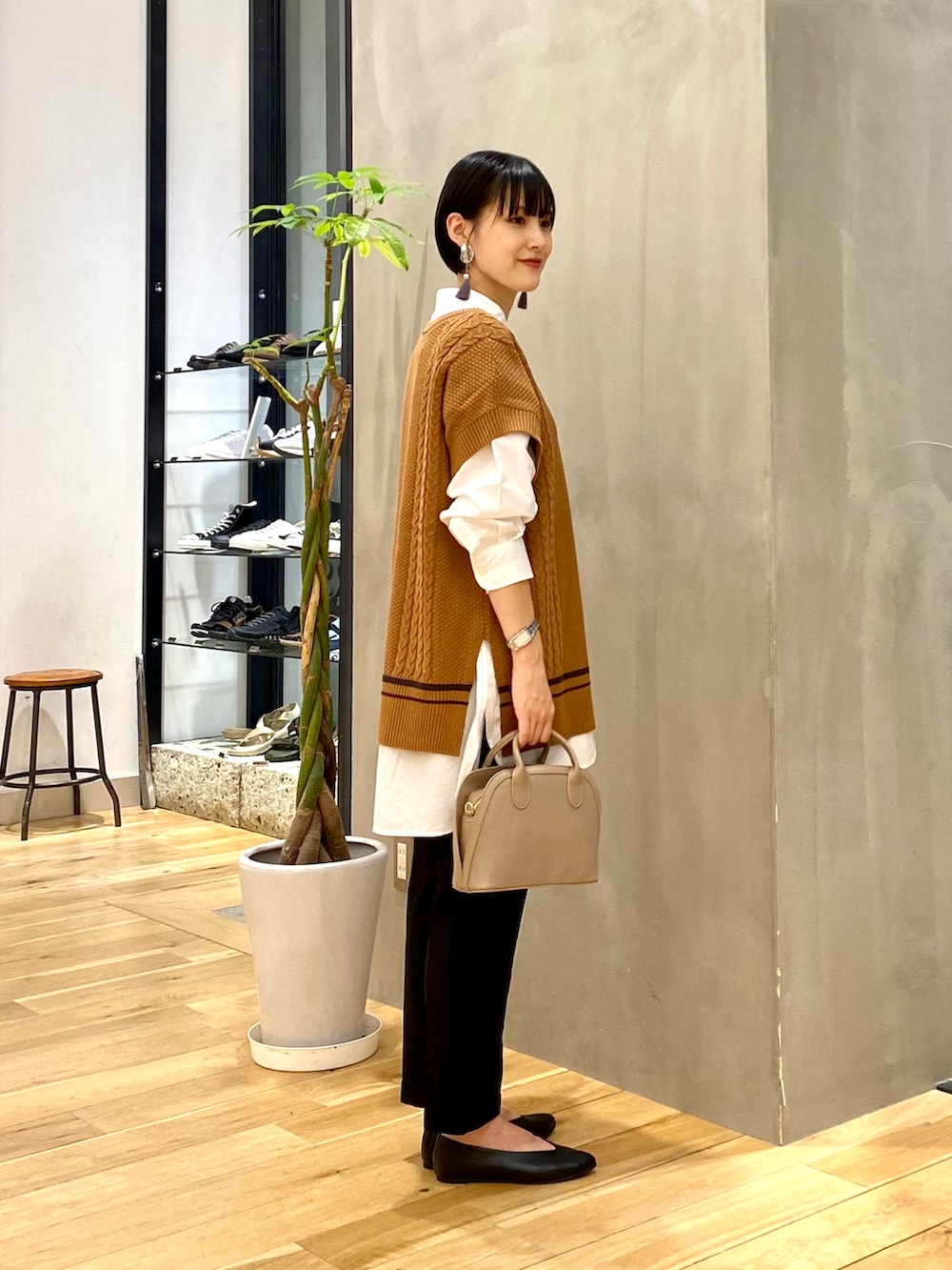 ホワイト系のシャツ/ブラウス、イエロー系のニット/セーター、ブラック系のその他パンツを着用したレディースの秋コーディネートの3枚目の写真