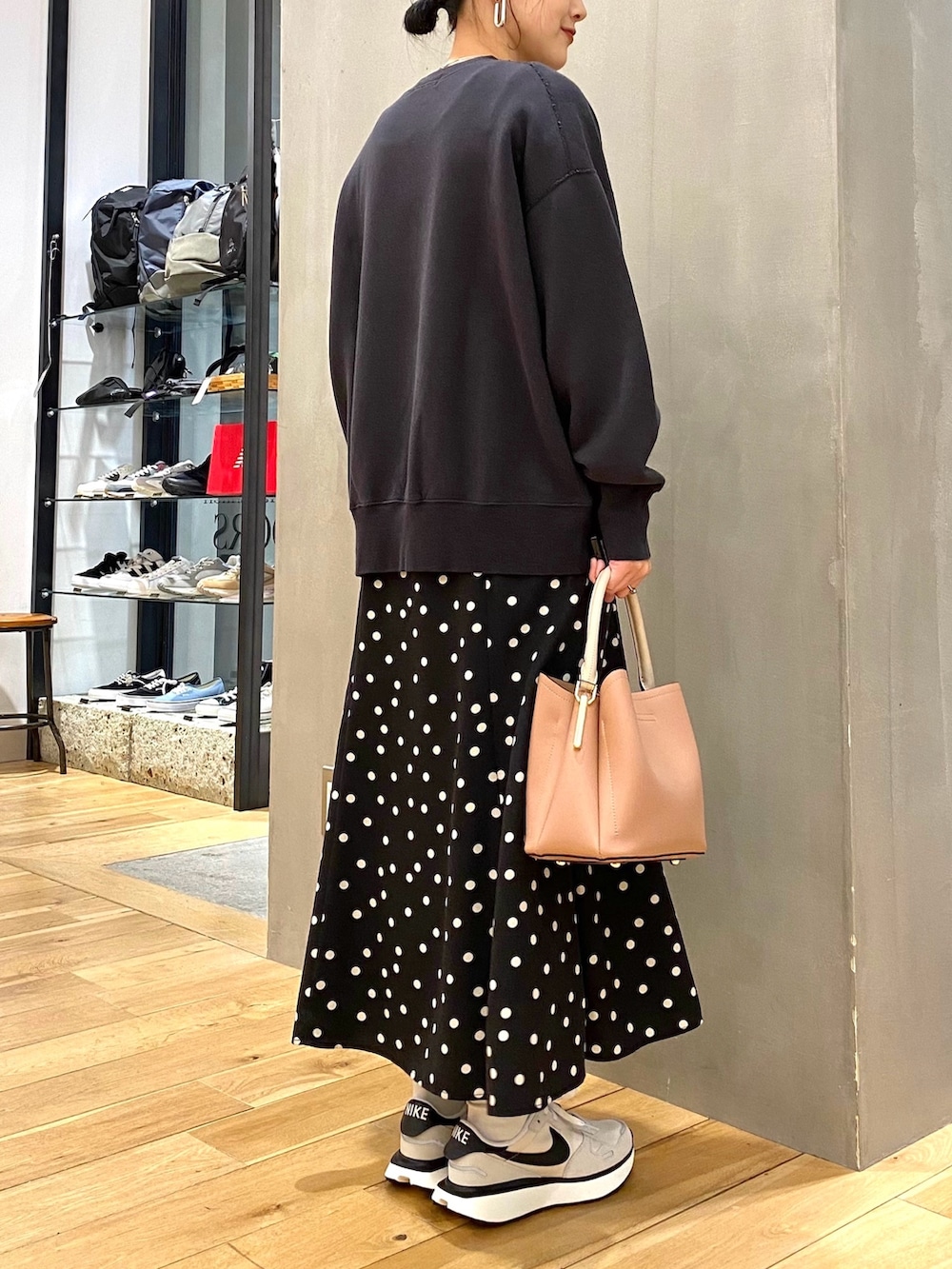 グレー系のスウェット、ブラック系のスカート、ピンク系のショルダーバッグを着用したレディースの春コーディネートの4枚目の写真