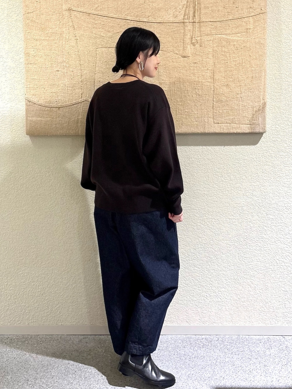 ブラウン系のニット/セーター、ブラウン系のニット/セーター、ブルー系のデニムパンツを着用したレディースの秋コーディネートの3枚目の写真