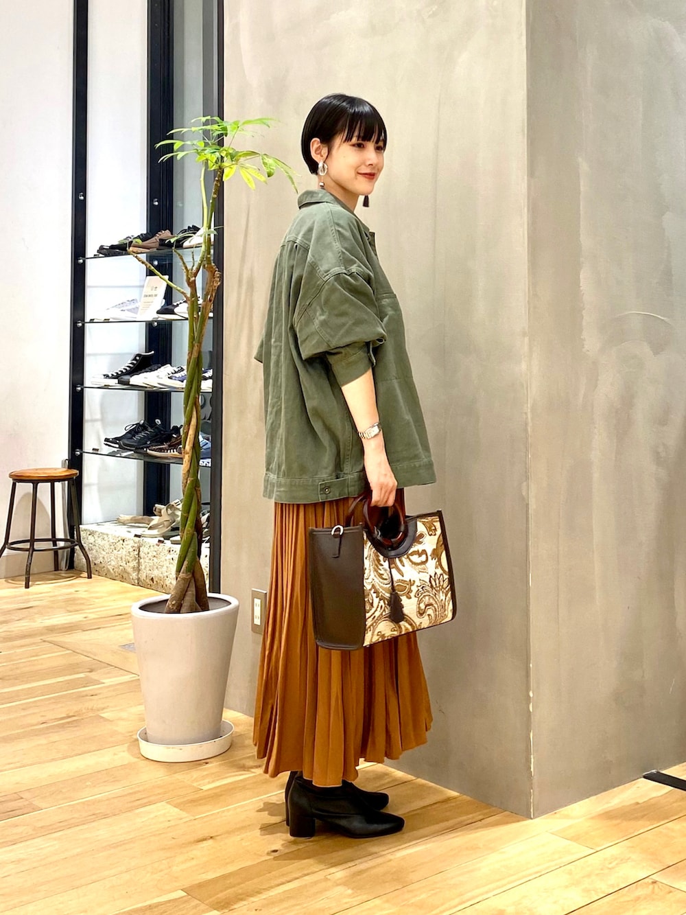 グリーン系のその他アウター、ホワイト系のTシャツ/カットソー、イエロー系のスカートを着用したレディースの秋コーディネートの2枚目の写真