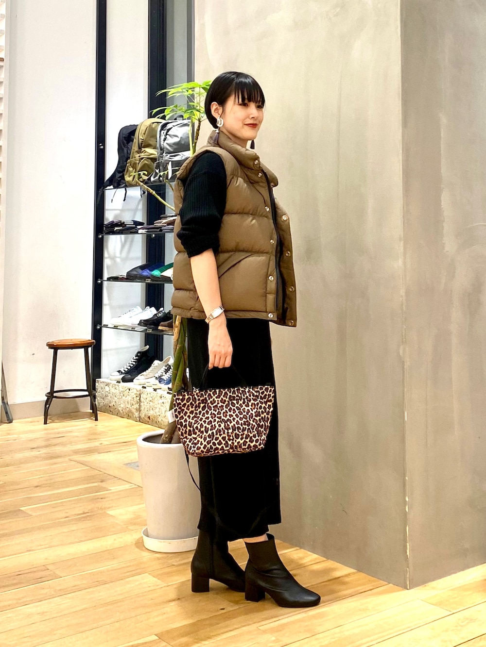 ベージュ系のダウンベスト、ブラック系のワンピース、その他のショルダーバッグを着用したレディースの秋コーディネートの3枚目の写真