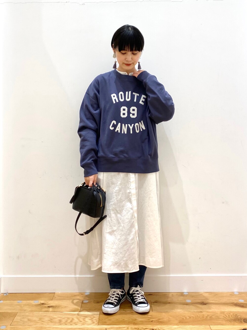 ブラック系のダウンジャケット/コート、ブルー系のスウェット、ホワイト系のワンピースを着用したレディースの冬コーディネートの4枚目の写真