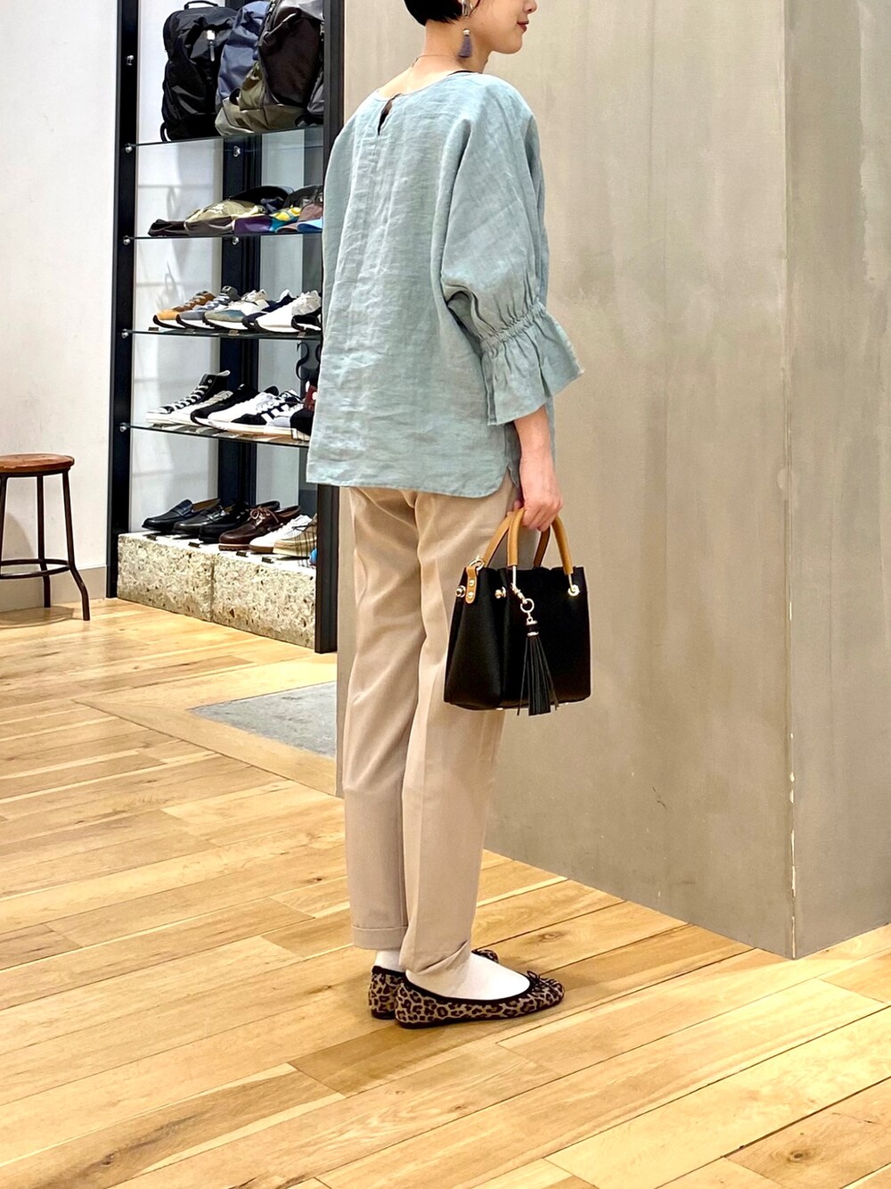 グリーン系のシャツ/ブラウス、ベージュ系のその他パンツ、ブラック系のトートバッグを着用したレディースの春コーディネートの5枚目の写真