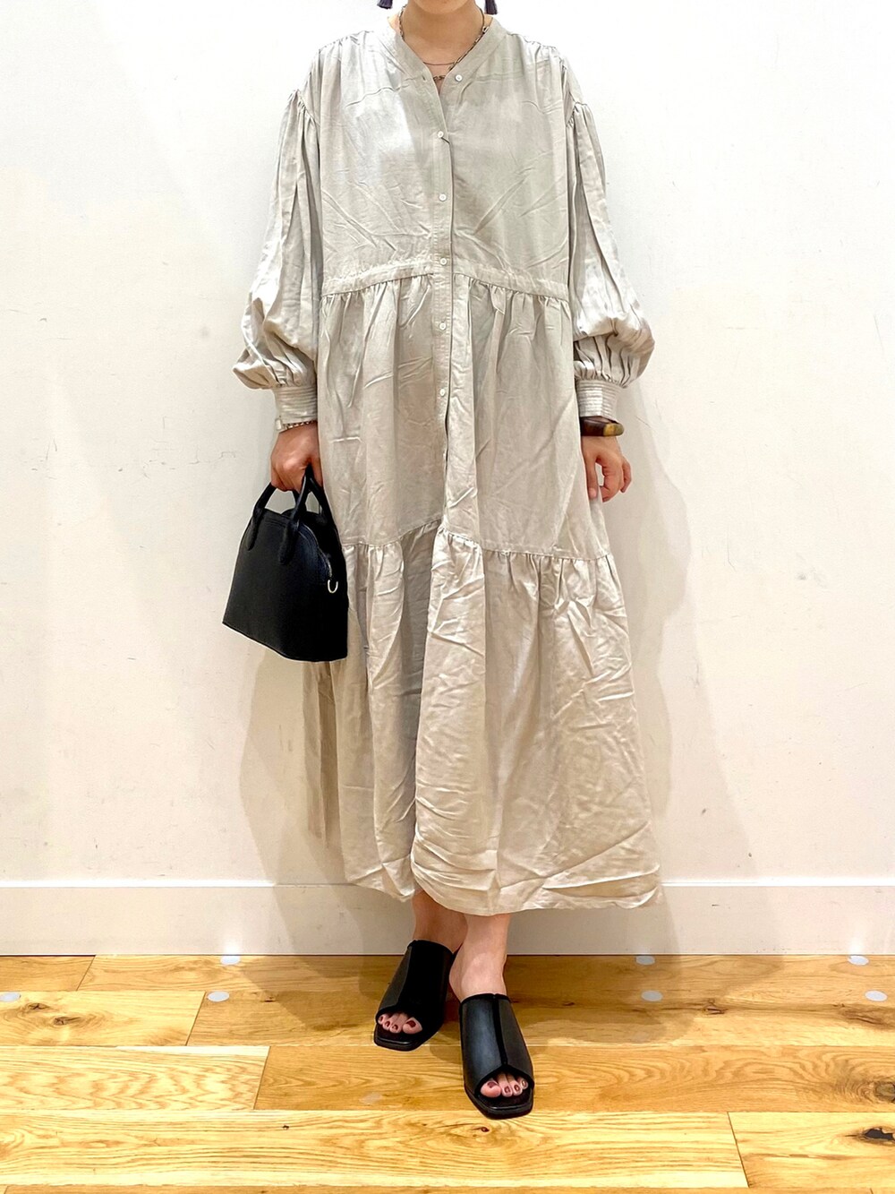 グレー系のワンピース、ブラック系のショルダーバッグ、ブラック系のサンダルを着用したレディースの夏コーディネートの4枚目の写真