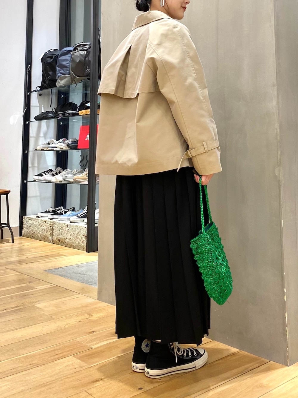 ベージュ系のトレンチコート、ホワイト系のTシャツ/カットソー、ブラック系のワンピースを着用したレディースの冬コーディネートの4枚目の写真