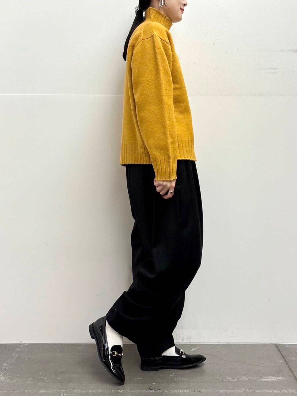ブラック系のローファー、イエロー系のニット/セーター、ブラック系のその他パンツを着用したレディースの冬コーディネートの8枚目の写真