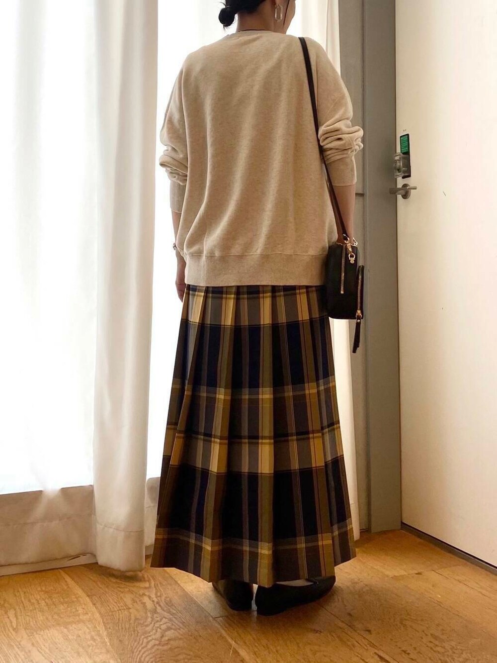 ブラック系のローファー、ブラック系のショルダーバッグ、ブルー系のスカートを着用したレディースの秋コーディネートの7枚目の写真