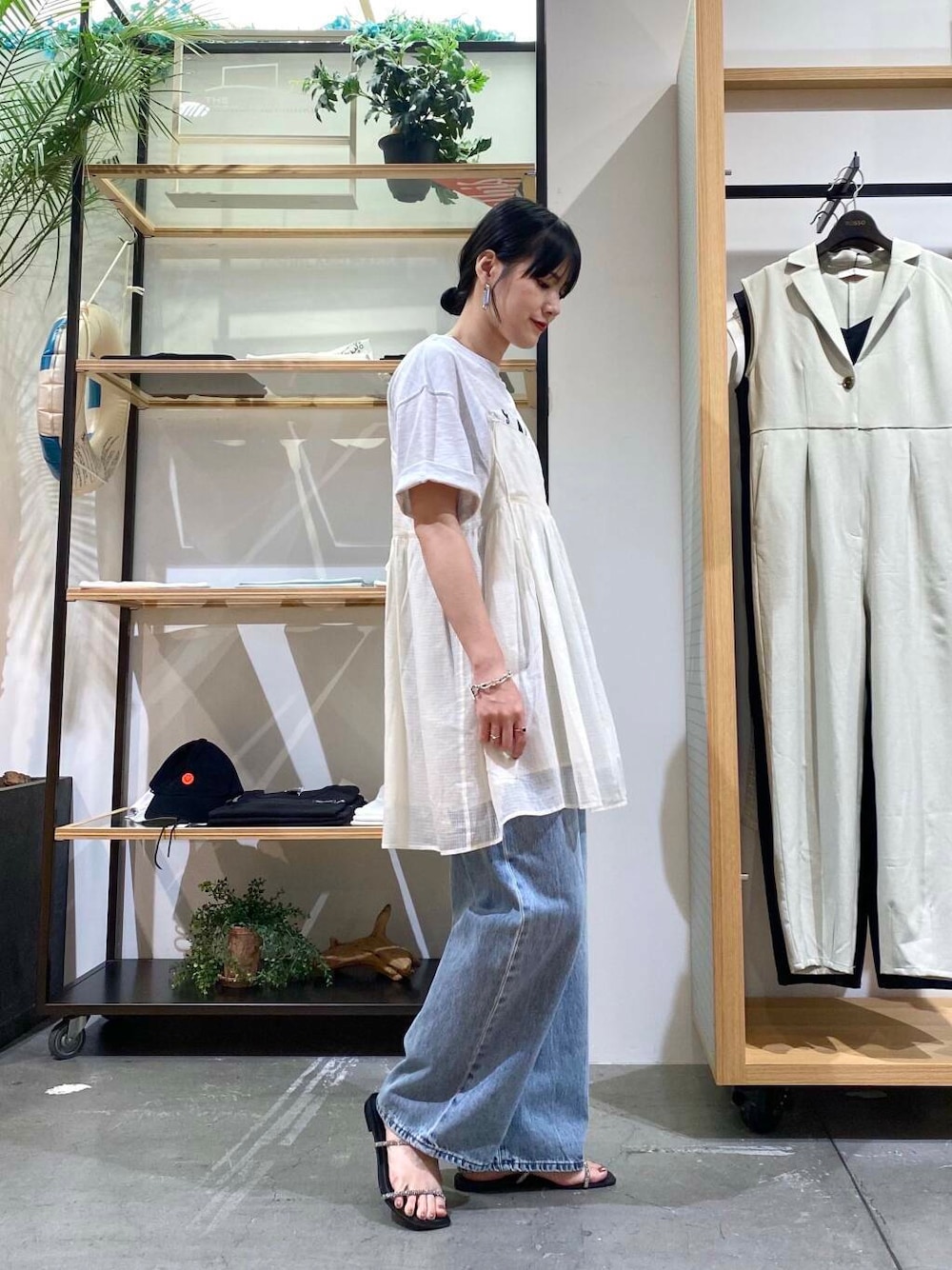 ブルー系のデニムパンツ、グレー系のTシャツ/カットソー、ブラック系のサンダルを着用したレディースの夏コーディネートの3枚目の写真