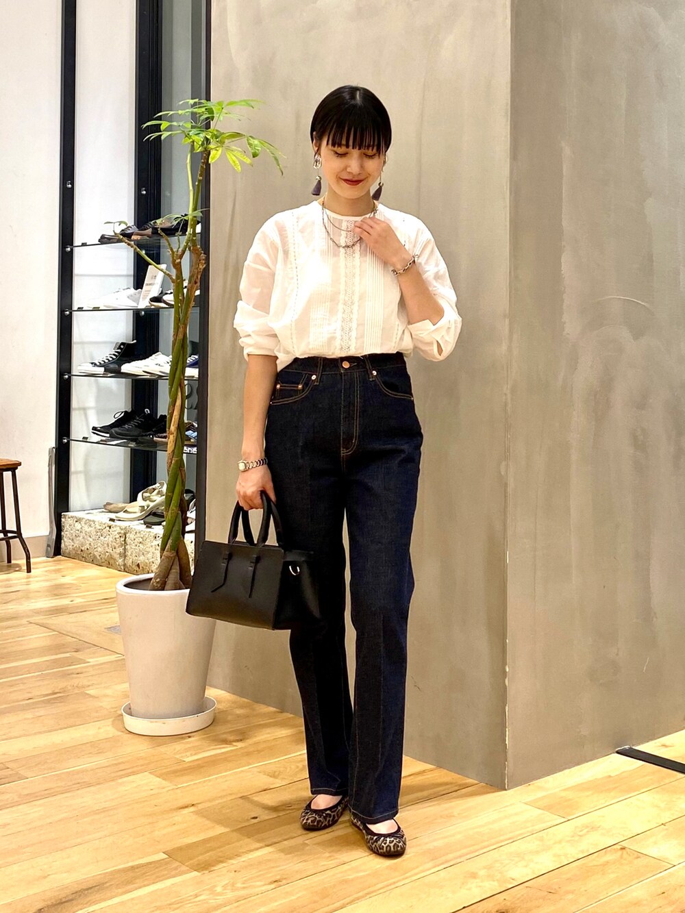 ブラウン系のカーディガン/ボレロ、ホワイト系のTシャツ/カットソー、ブルー系のデニムパンツを着用したレディースの秋コーディネートの3枚目の写真