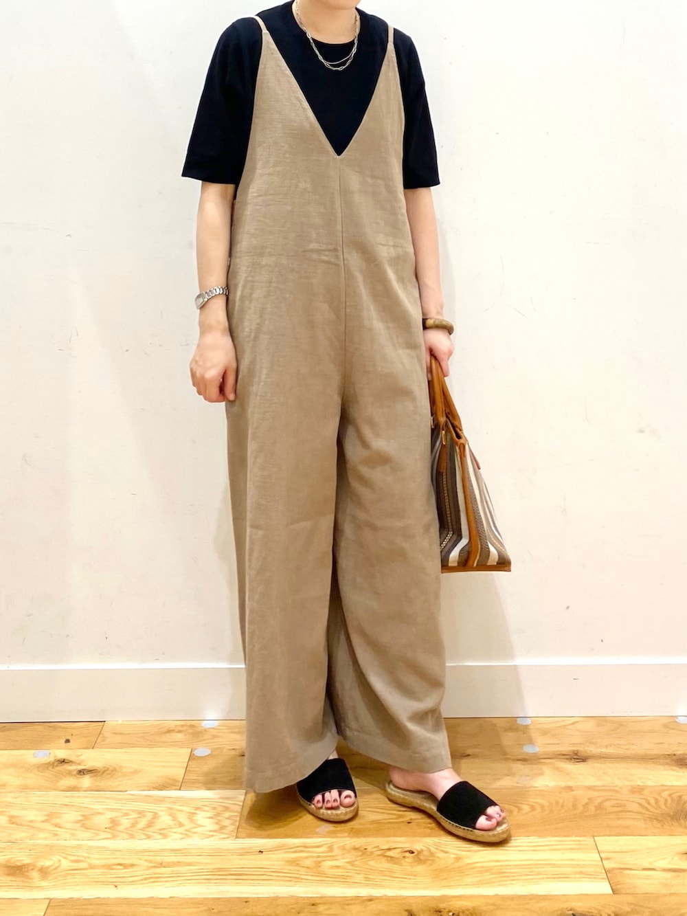 ブラック系のニット/セーター、ベージュ系のサロペット/オーバーオール、イエロー系のトートバッグを着用したレディースの春コーディネートの4枚目の写真