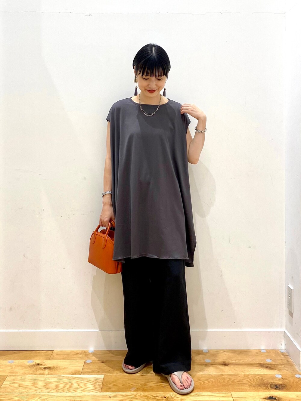 グレー系のTシャツ/カットソー、ブラック系のその他パンツ、オレンジ系のショルダーバッグを着用したレディースの夏コーディネートの2枚目の写真