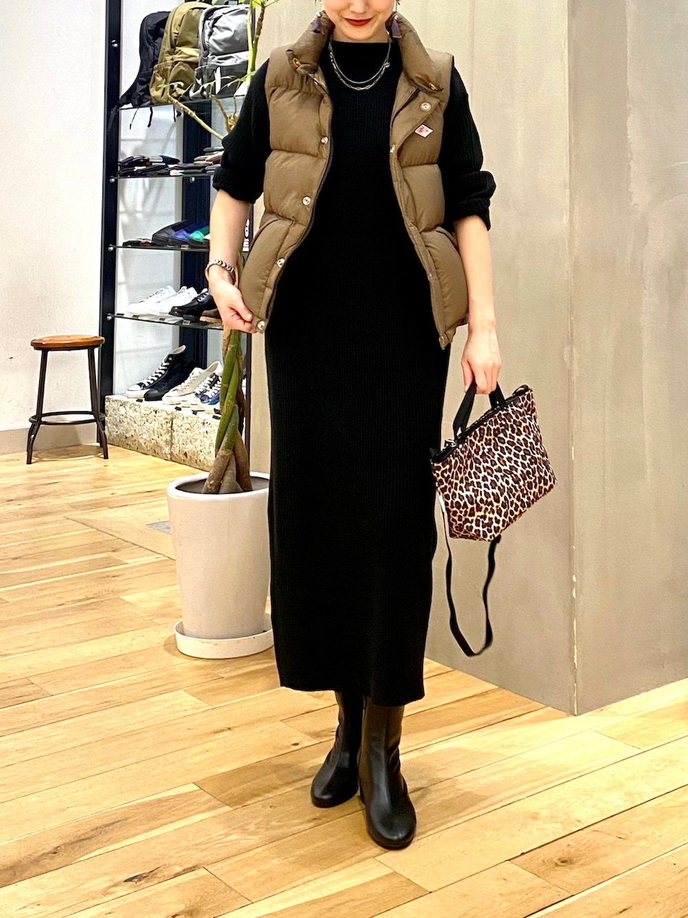 ベージュ系のダウンベスト、ブラック系のワンピース、その他のショルダーバッグを着用したレディースの秋コーディネートの4枚目の写真
