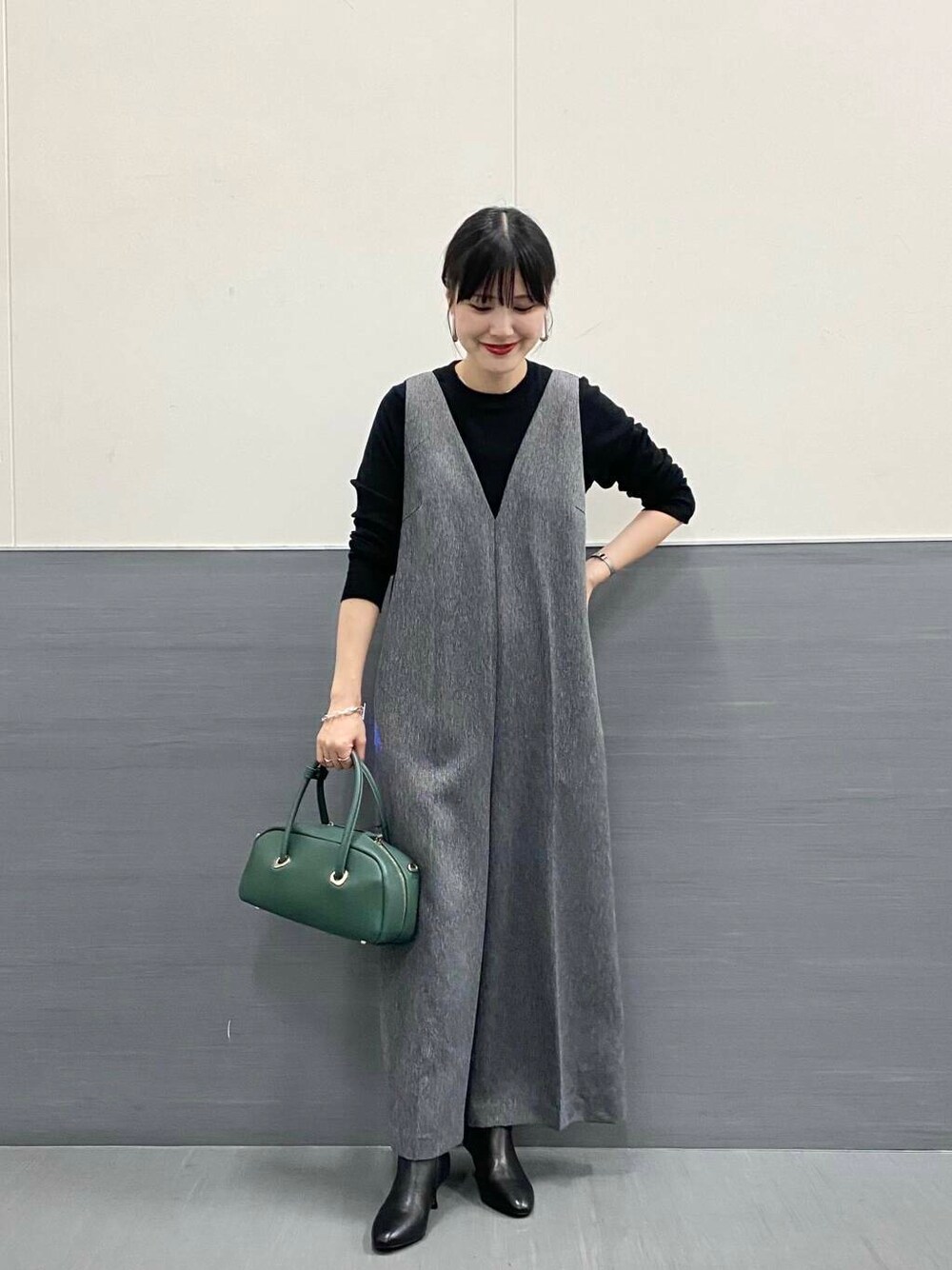 ブラック系のTシャツ/カットソー、グレー系のサロペット/オーバーオール、ブラック系のブーツを着用したレディースの秋コーディネートの2枚目の写真