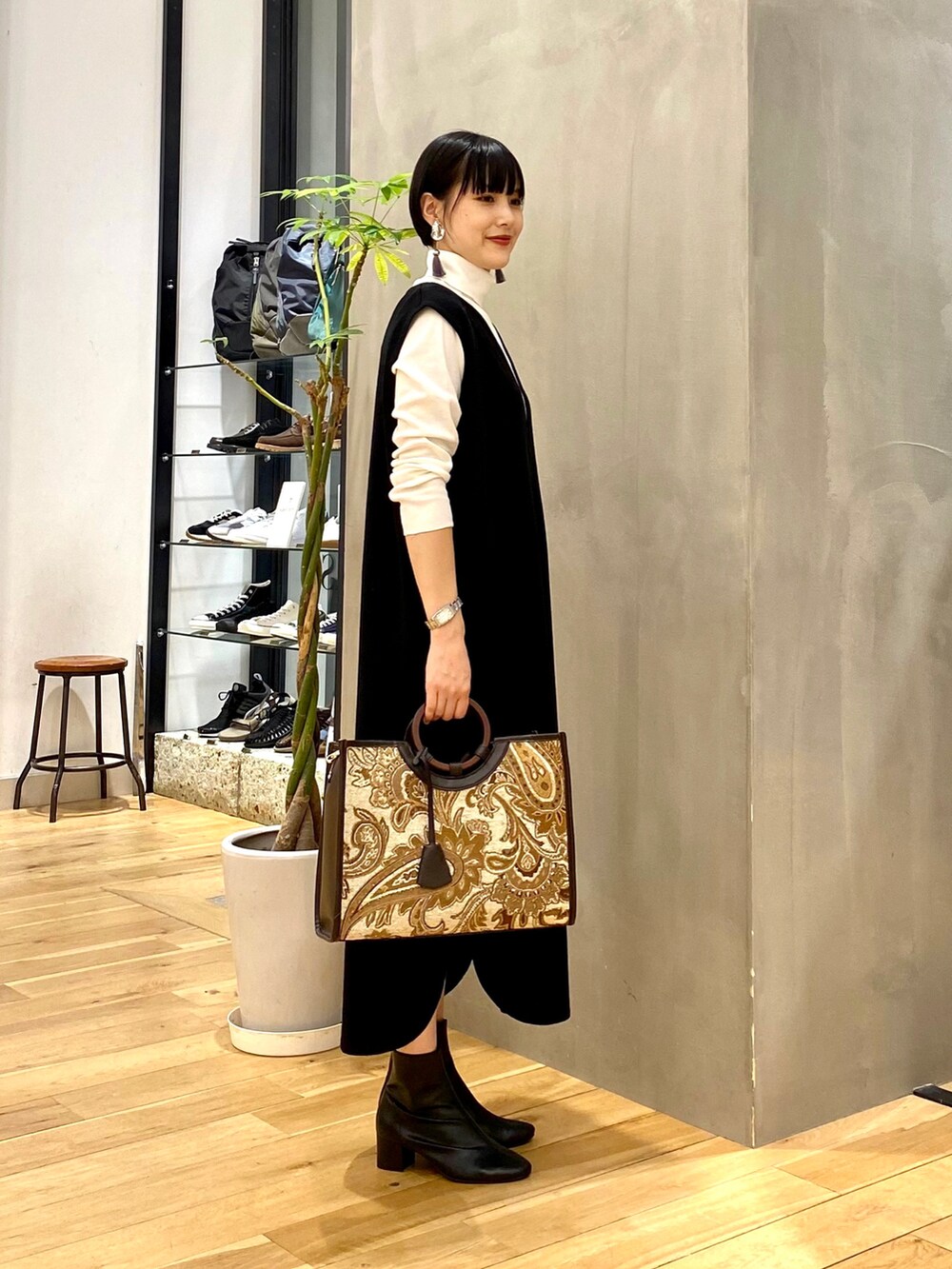 ホワイト系のTシャツ/カットソー、ブラック系のワンピース、ブラウン系のトートバッグを着用したレディースの秋コーディネートの3枚目の写真