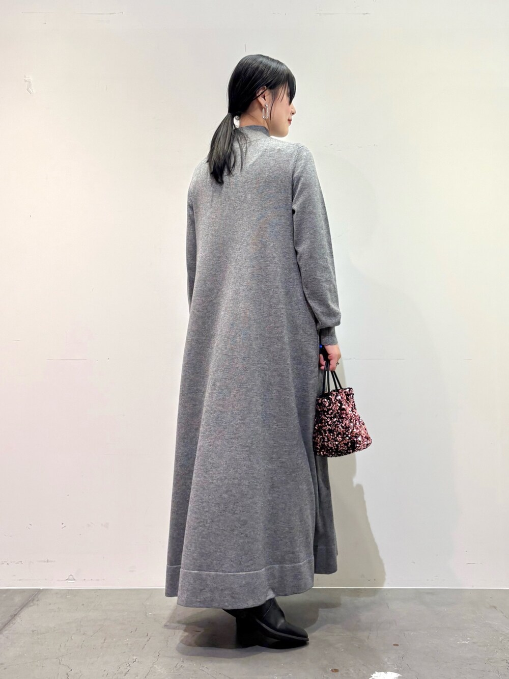 ブラック系のダウンジャケット/コート、グレー系のワンピース、ピンク系のショルダーバッグを着用したレディースの冬コーディネートの6枚目の写真