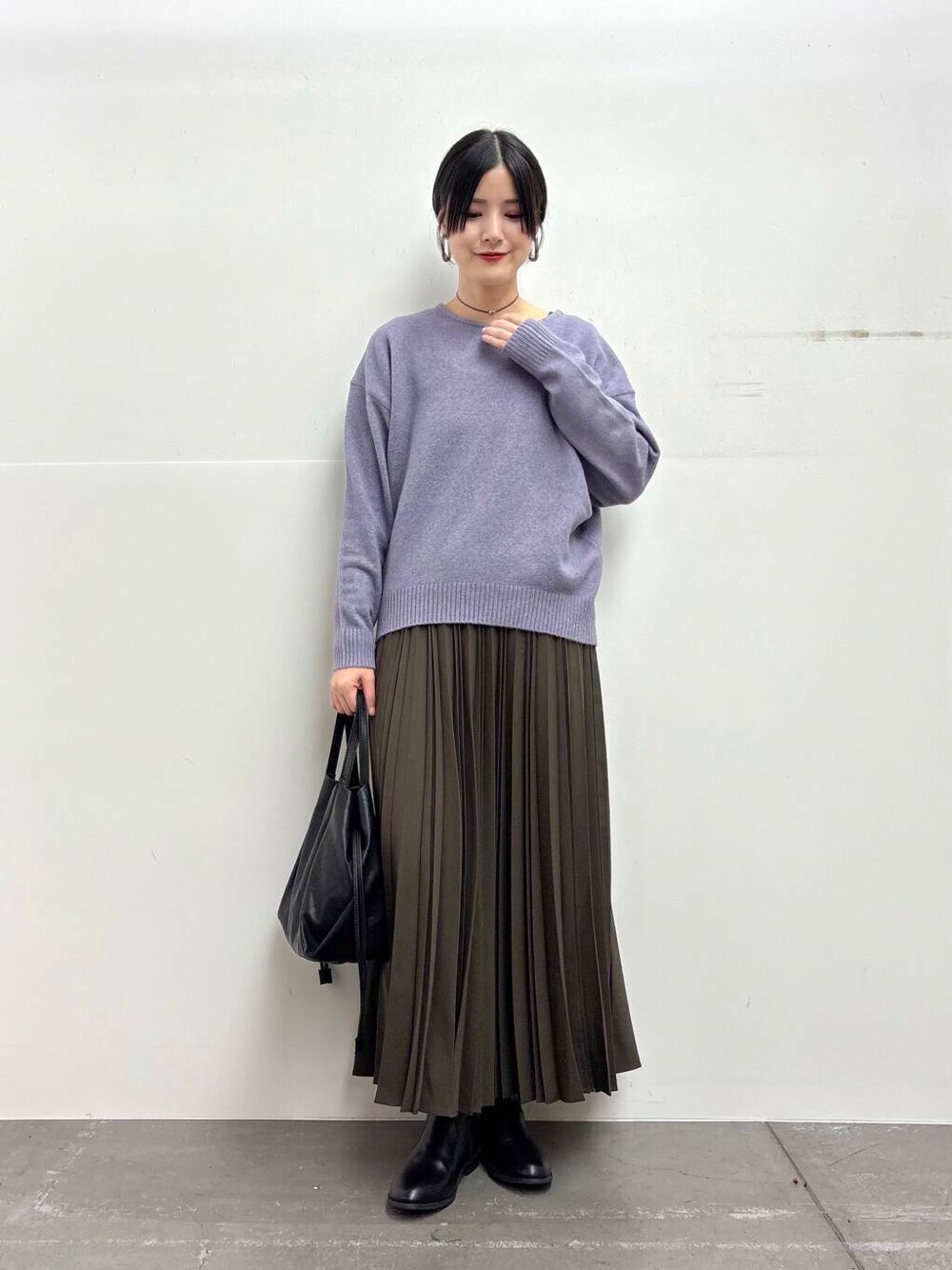 ブラック系のショルダーバッグ、ホワイト系のダウンジャケット/コート、ブラック系のブーツを着用したレディースの冬コーディネートの4枚目の写真