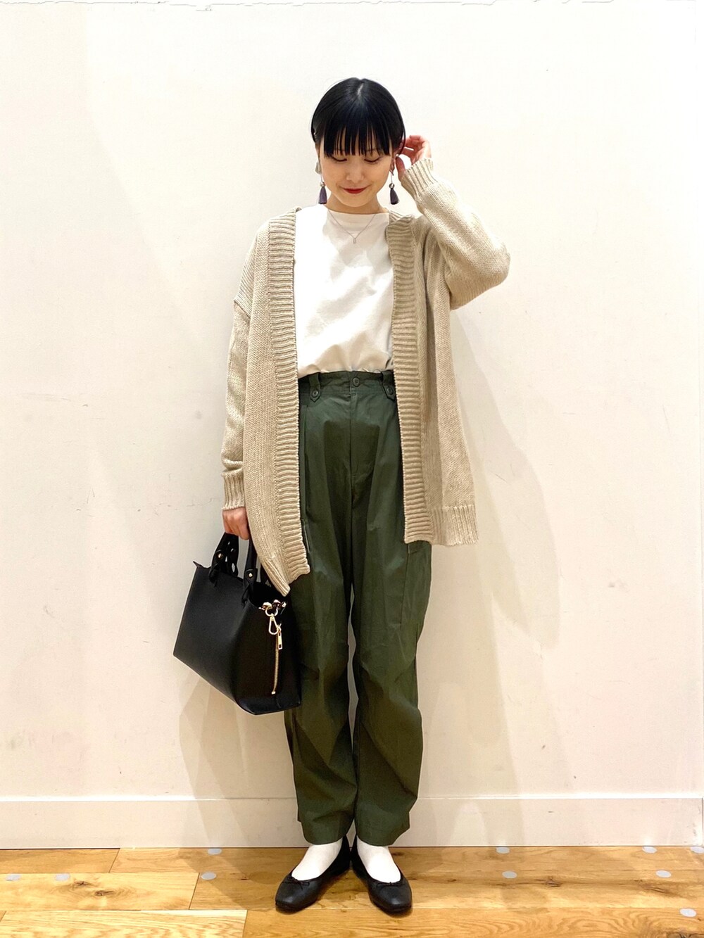 ホワイト系のTシャツ/カットソー、グリーン系のその他パンツ、ブラック系のトートバッグを着用したレディースの春コーディネートの2枚目の写真