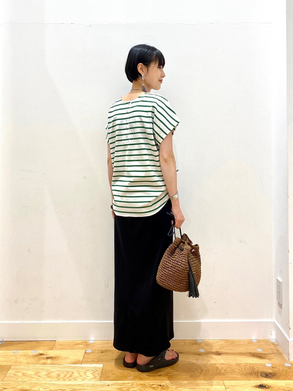 グリーン系のTシャツ/カットソー、ブラック系のスカート、ブラウン系のショルダーバッグを着用したレディースの夏コーディネートの3枚目の写真