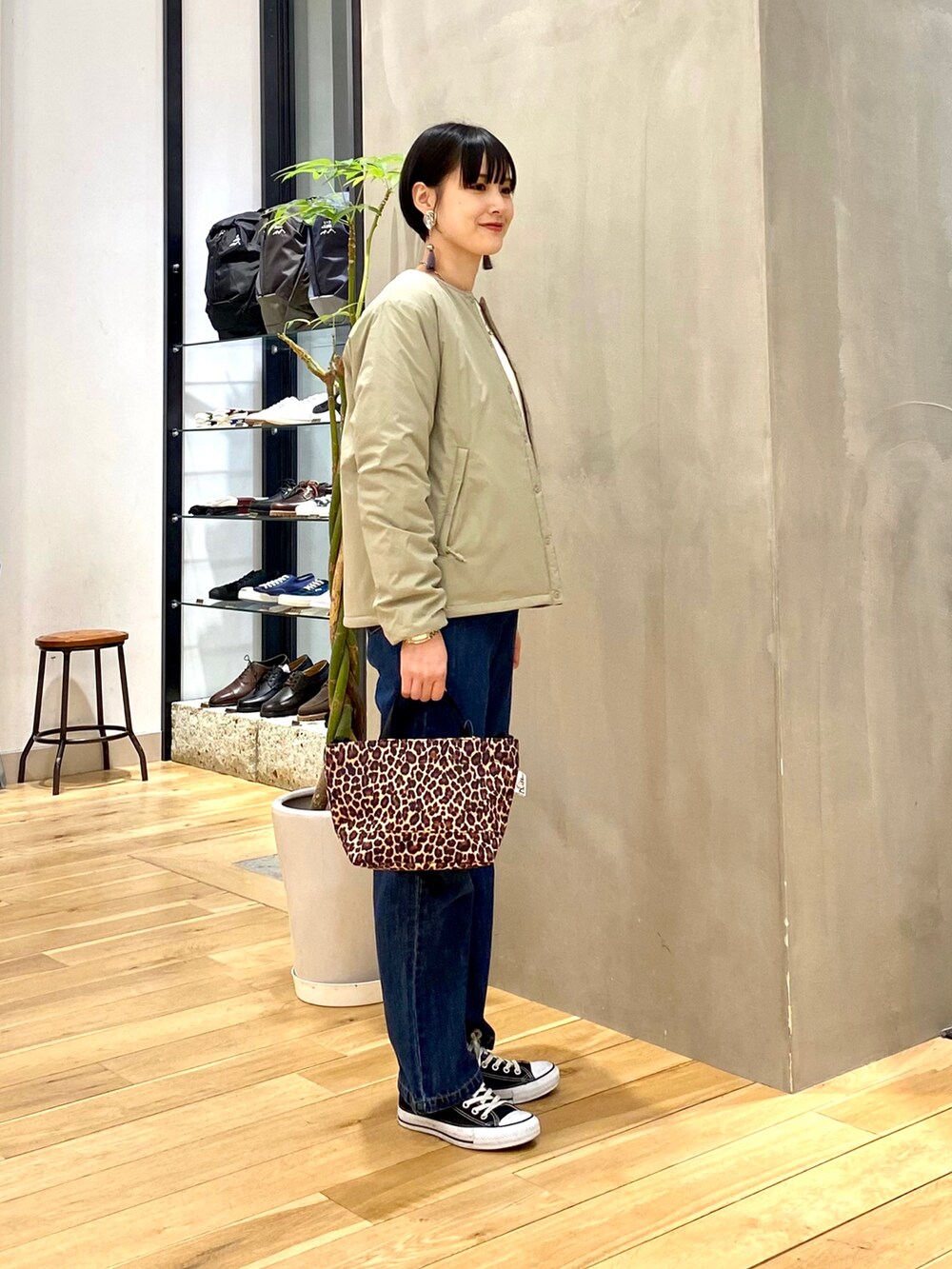 グリーン系のその他アウター、ホワイト系のニット/セーター、ブルー系のデニムパンツを着用したレディースの冬コーディネートの3枚目の写真