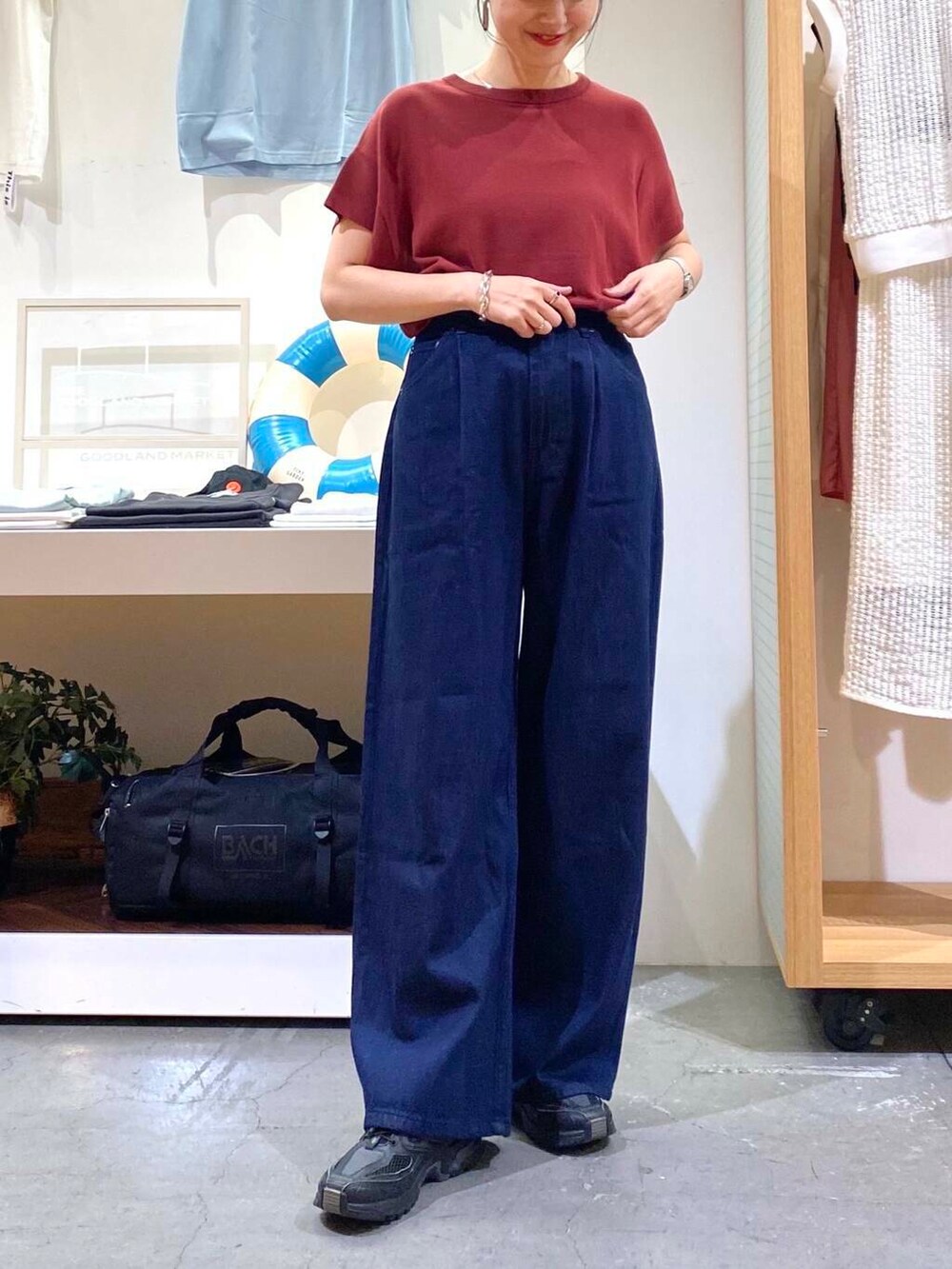 レッド系のニット/セーター、ブルー系のデニムパンツを着用したレディースの夏コーディネートの5枚目の写真