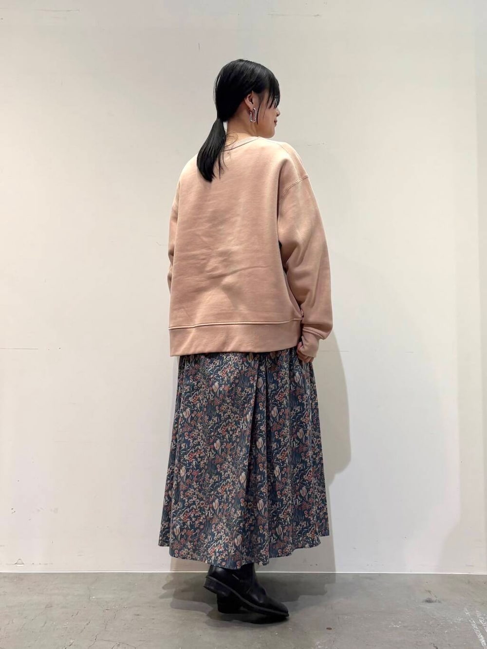 ブラック系のブーツ、ブルー系のスカート、ピンク系のスウェットを着用したレディースの冬コーディネートの3枚目の写真