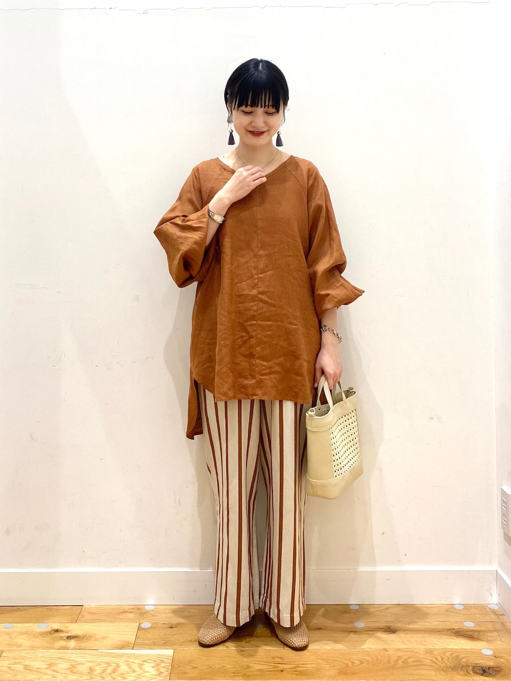 ブラウン系のシャツ/ブラウス、ホワイト系のその他パンツ、イエロー系のサンダルを着用したレディースの春コーディネートの2枚目の写真