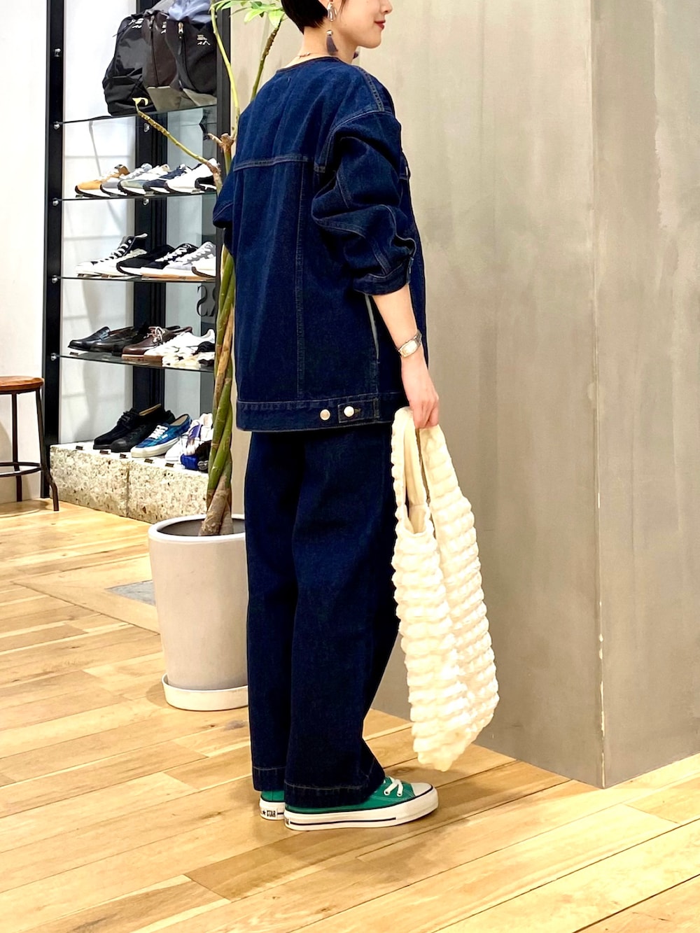 ブルー系のデニムジャケット、ブルー系のデニムパンツ、ホワイト系のトートバッグを着用したレディースの冬コーディネートの5枚目の写真