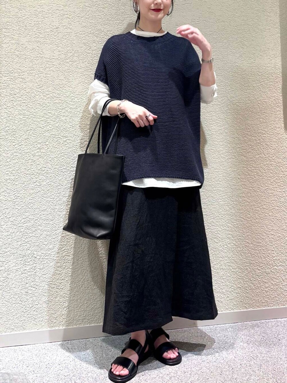 ホワイト系のシャツ/ブラウス、ブルー系のベスト、ブラック系のスカートを着用したレディースの春コーディネートの4枚目の写真