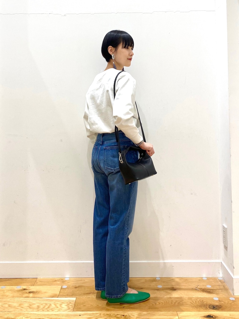 ベージュ系のステンカラーコート、ホワイト系のTシャツ/カットソー、ブルー系のデニムパンツを着用したレディースの春コーディネートの5枚目の写真