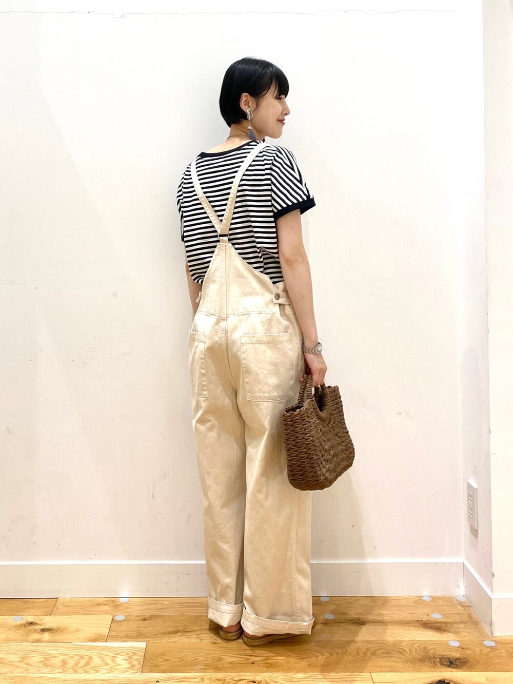 ホワイト系のTシャツ/カットソー、ホワイト系のサロペット/オーバーオール、ブラウン系のハンドバッグを着用したレディースの春コーディネートの4枚目の写真