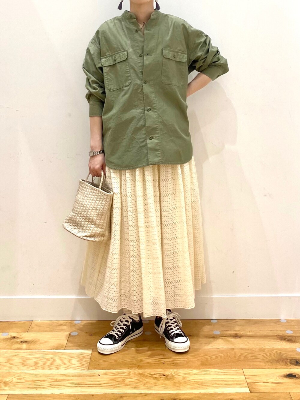 グリーン系のシャツ/ブラウス、ホワイト系のスカート、ブラック系のスニーカーを着用したレディースの春コーディネートの4枚目の写真