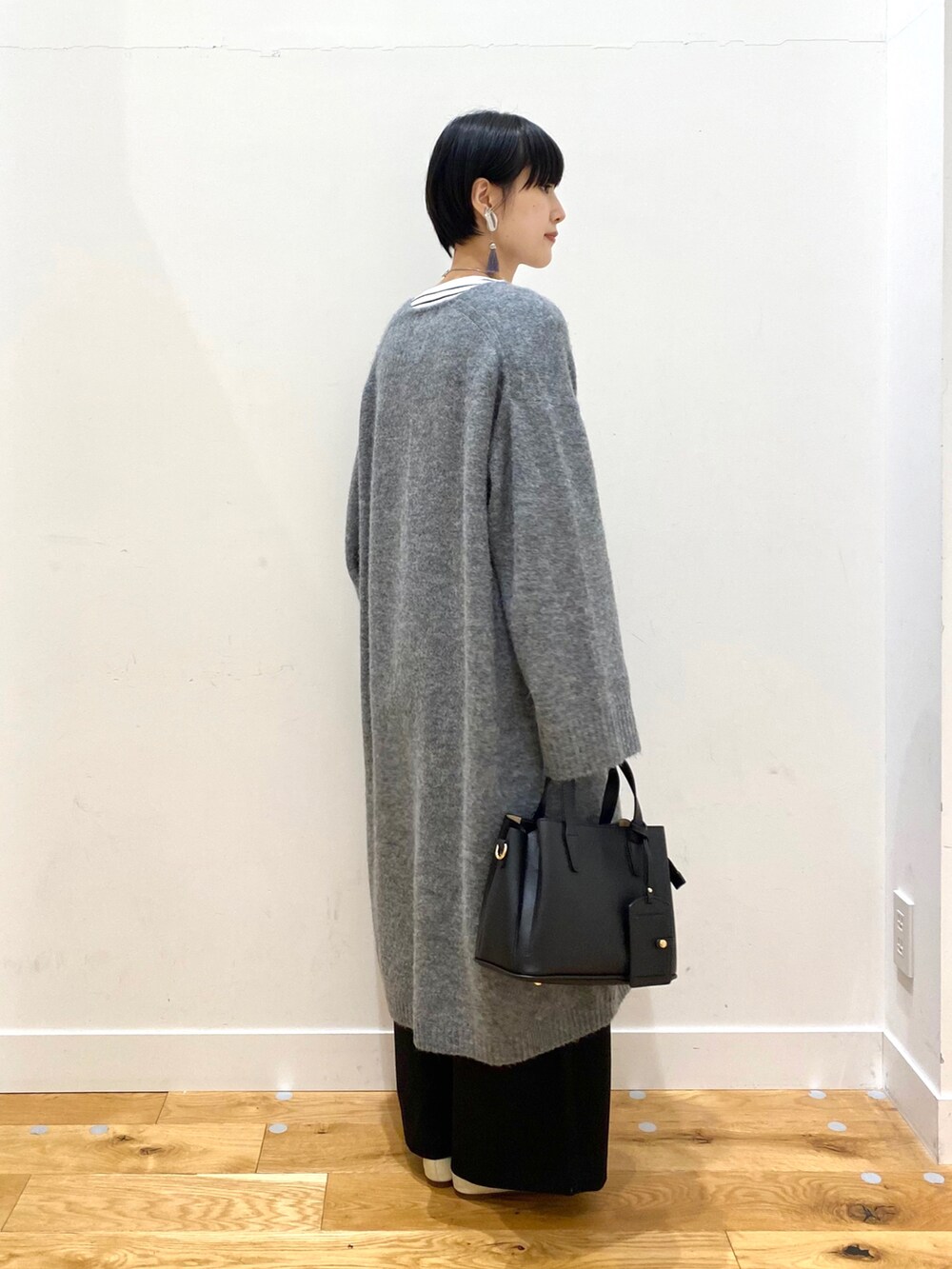グレー系のカーディガン/ボレロ、ホワイト系のTシャツ/カットソー、ブラック系のその他パンツを着用したレディースの秋コーディネートの3枚目の写真