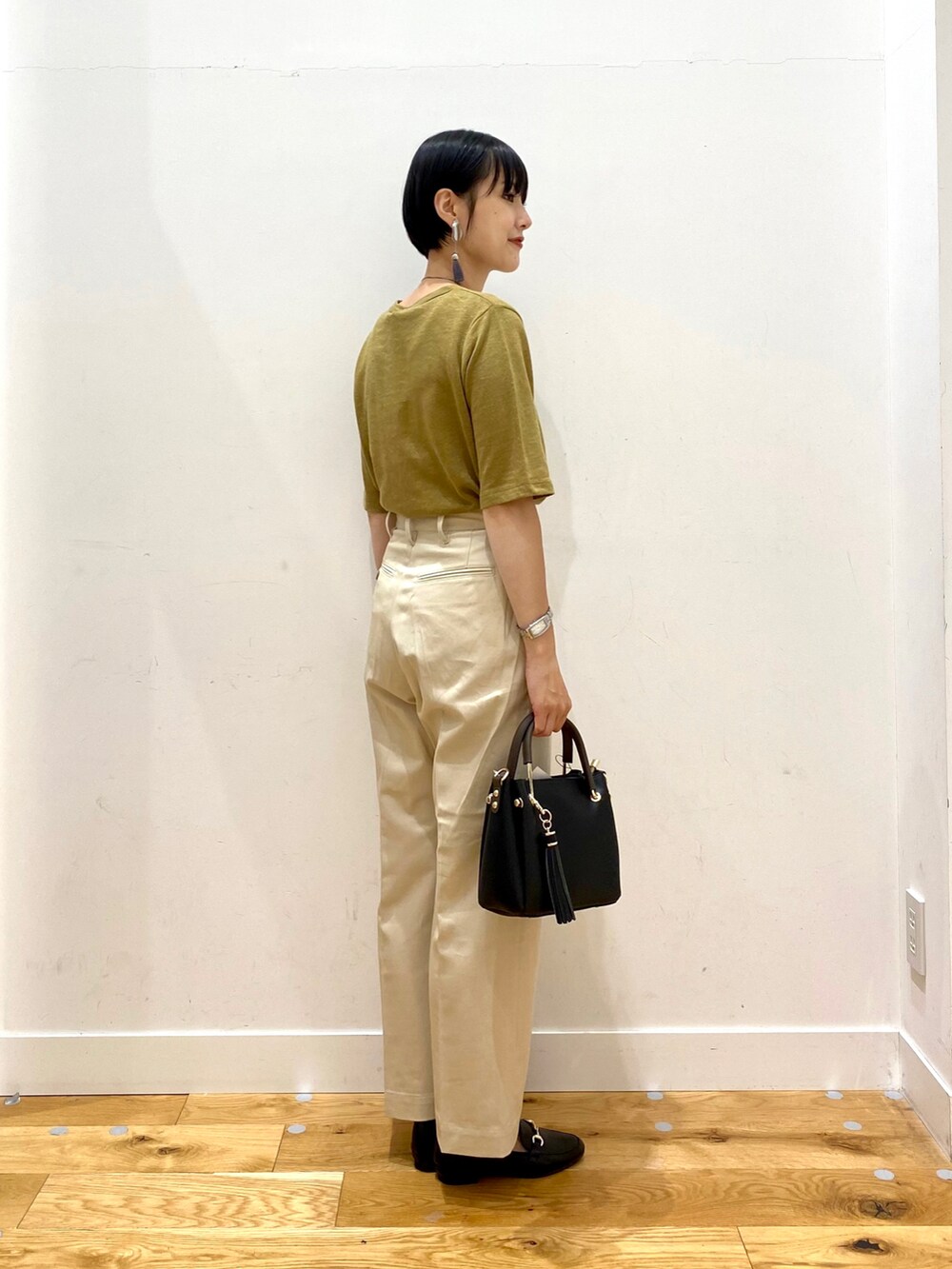 イエロー系のTシャツ/カットソー、ベージュ系のその他パンツ、ブラック系のトートバッグを着用したレディースの夏コーディネートの3枚目の写真