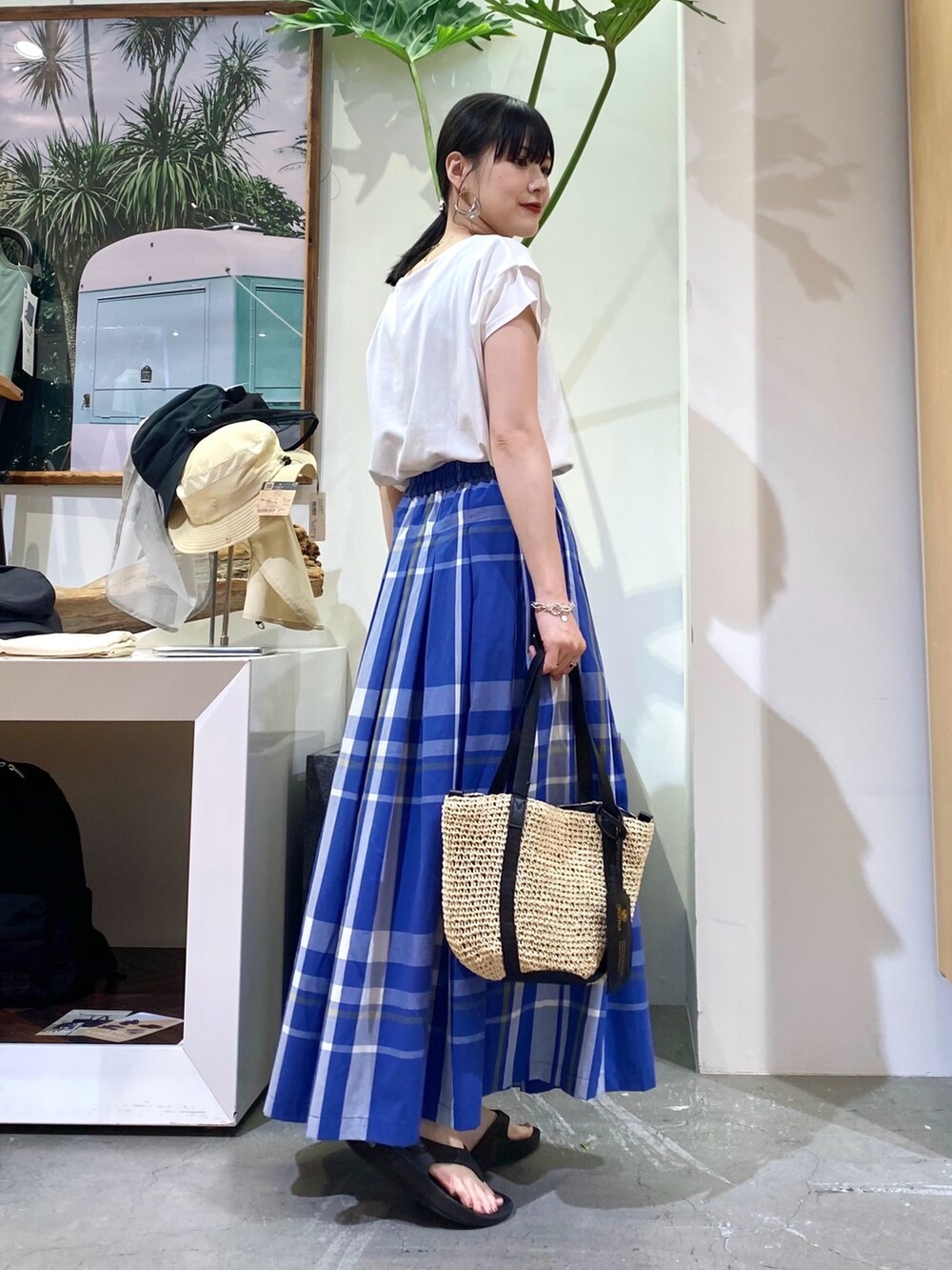 ホワイト系のTシャツ/カットソー、ブルー系のスカート、ベージュ系のトートバッグを着用したレディースの夏コーディネートの3枚目の写真