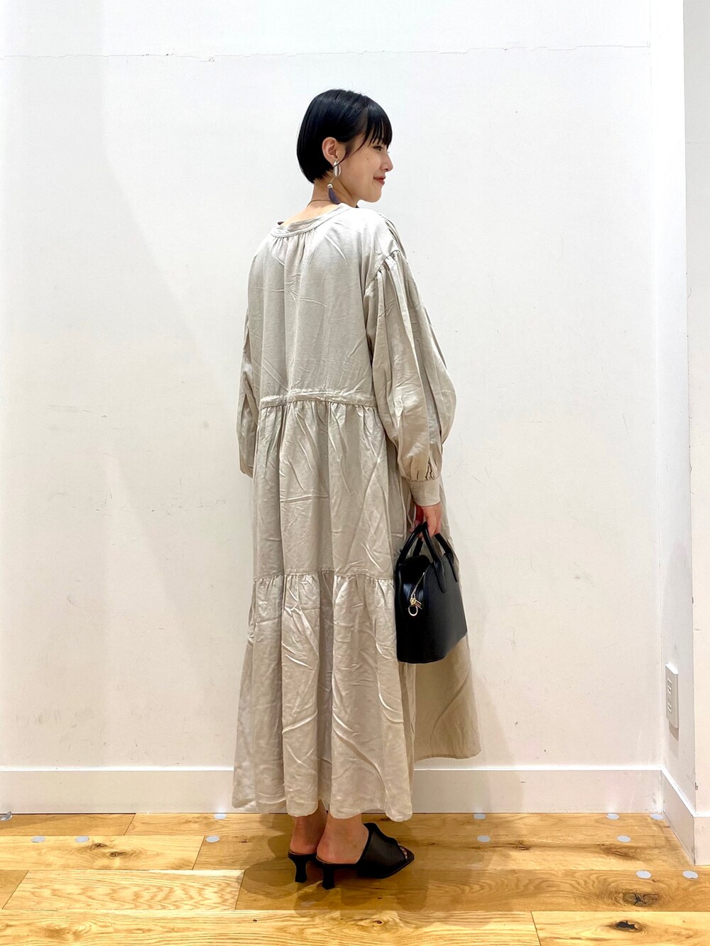 グレー系のワンピース、ブラック系のショルダーバッグ、ブラック系のサンダルを着用したレディースの夏コーディネートの3枚目の写真