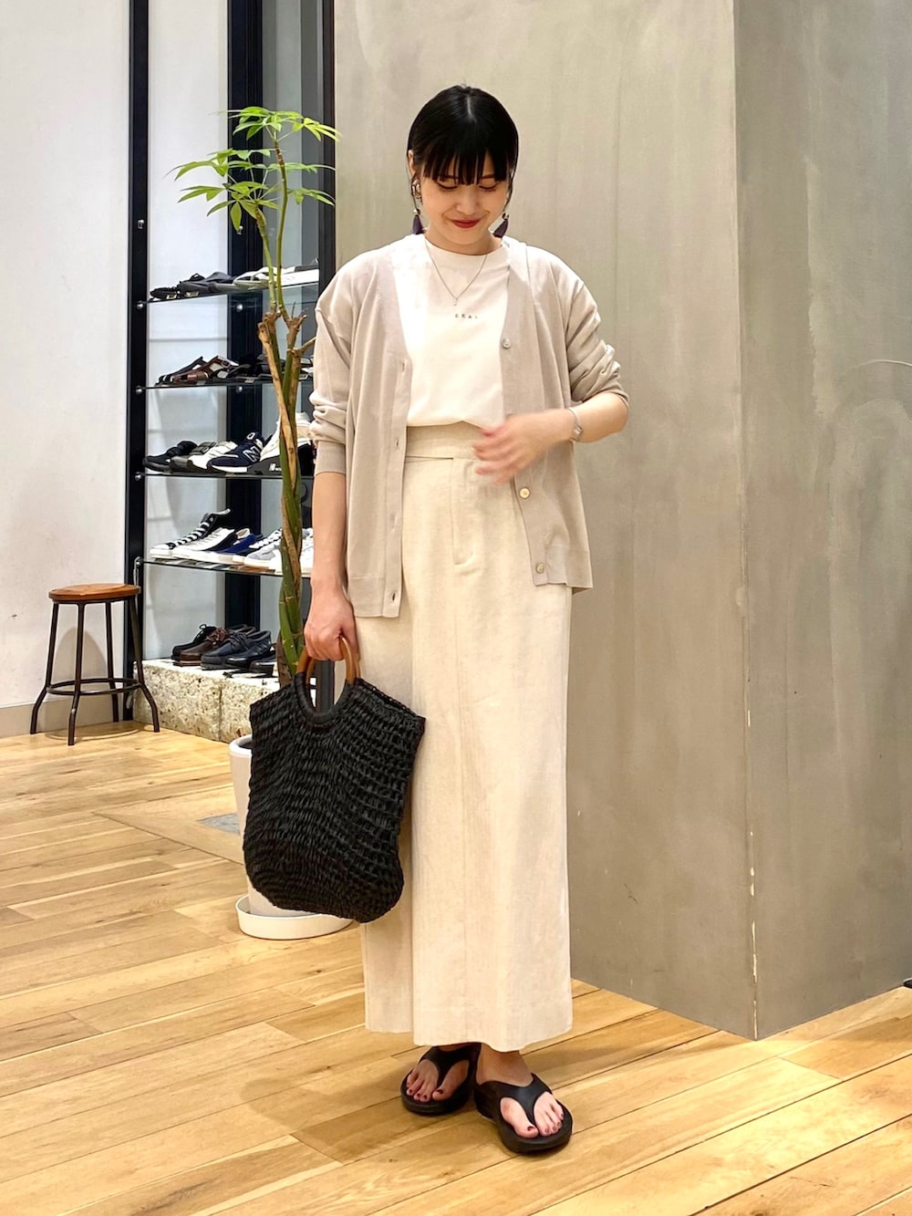 グレー系のカーディガン/ボレロ、ホワイト系のTシャツ/カットソー、ベージュ系のスカートを着用したレディースの春コーディネートの3枚目の写真